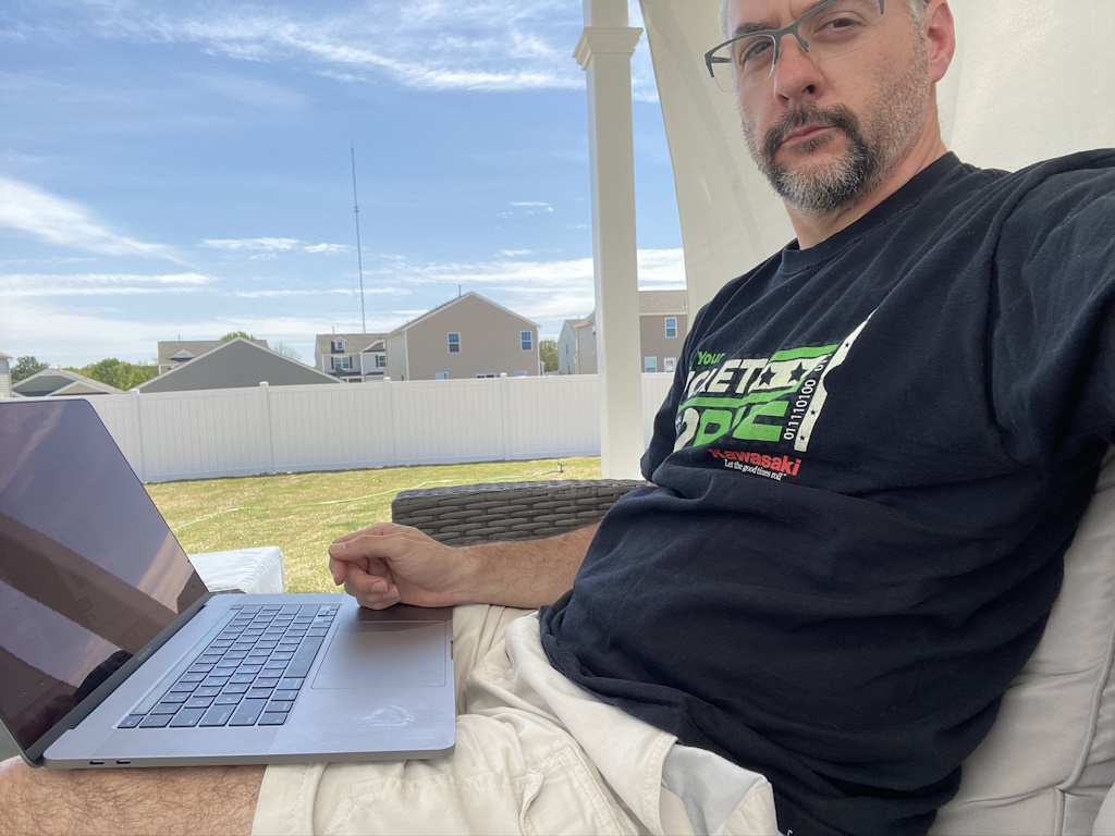 Kevin sitting outside with a MacBook Pro laptop